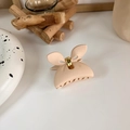 Detail view of a matte peach bow-shaped hair claw clip with golden metal hardware hinge - Beige Bowknot