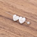 DIY shell heart bead safety pin with white pearl and golden letter L on wood surface - Letter L