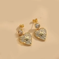 Détail de boucles d'oreilles cœur et étoile dorées avec pavé de cristaux brillants - Forme de cœur et d'étoile