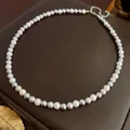 Elegant pearl necklace with alternating white and dark grey pearls on leather surface - Gray Series Pearl Style