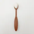 Toothbrush-shaped foundation brush with white dense bristles and a dark brown handle - Coffee