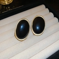 Macro shot of oval vintage earrings with black resin inlay and gold-tone metal frames - Gold Black (Silver Pin)