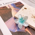 Dettaglio della pinza per capelli a forma di plumeria da 4cm su una lastra di pietra ruvida - Fiore Blu Oceano Piccolo (4cm)