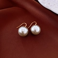 Primer plano de aretes de perlas grandes en seda con ganchos largos chapados en oro - Gancho de Perla Gris 13mm