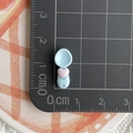 Macro detail of mini light blue resin spoon with pink heart on a scaled cutting mat - Heart Spoon / Blue