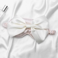 Pink silk sleep mask with a large white satin bow and elastic strap for eye protection - Flesh Pink