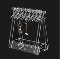 Clear acrylic jewelry organizer with mini clothes hangers for earrings on black background - Clear