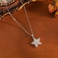 Detailed view of a silver star pendant with tiny clear crystals on brown velvet background - Silver Full Diamond Star Necklace