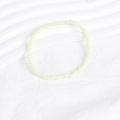 Close-up of minimalist cream yellow seed bead bracelet on a textured white surface - Creamy Yellow