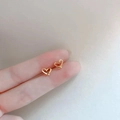 Minimalist gold hollow heart stud earrings for women shown on fingertips - Hollow Heart / Gold