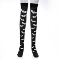 Detailed view of black thigh-high socks with white bat prints over the knees - One Size / Bat