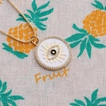 Detail of gold plated evil eye pendant with white enamel and sparkling zircon stones - White