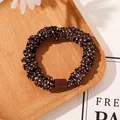 Detail of dark brown polka dot scrunchie fabric and elastic texture on wooden tray - Satin Polka Dot Coffee