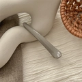 Detail view of a glossy grey hair clip on a minimalist textured fabric background - Glossy Gray