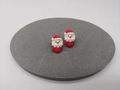 Detailansicht der Weihnachtsmann-Ohrstecker in Rot und Weiß auf grauem Samt - Weihnachtsmann