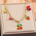 Détail du collier doré avec pendentifs émaillés en forme de fraise et de cerise - Collier