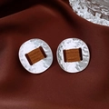 Detail of silver textured earrings with brown leather wrap on silk fabric - Silver with Coffee