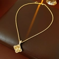 Macro shot of gold clover pendant with sparkling cubic zirconia on a leather surface - Gold (Real Gold Plated)