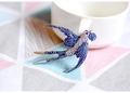Dettaglio di una spilla a rondine con strass blu e uno stile vintage elegante - Rondine con Sfera Spilla Blu