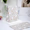 Mini gift bag with cute cartoon sheep and gold stars on light gray paper background - Lamb
