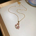 Macro view of 18k gold plated cherry blossom pendant with pink gems on a white tray - Necklace-Purple