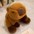 Cute brown plush capybara stuffed animal with sleeping eyes on a soft carpet - Capybara