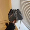 Modische schwarze Beuteltasche mit silbernen Strasssteinen und Metallkette in der Hand - Silber