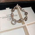 Dettaglio di bracciale con perle grigie e chiusura rotonda con cristalli scintillanti - Argento