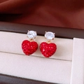 Primo piano di orecchini a cuore con strass rossi e zircone in una confezione regalo - Perno per orecchini in argento-Oro-Rosso
