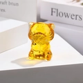 Close-up of translucent amber glass tiger figurine on a white tiered display stand - Zodiac Tiger / Gold Yellow