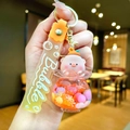 Close-up of a cute glowing pig keychain featuring a floating sand bottle and yellow strap - Gradient Rope [orange] Glow-in-the-dark Pvc Peach Pig