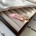 Détail de la pince à cheveux en résine rose avec cristaux sur un plateau à bijoux beige - Rose Crème Fraise