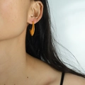 Boucles d'oreilles minimalistes en forme de croissant doré mat portées par un mannequin - Doré
