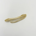 Detail of a sleek gold-tone irregular spring hair clip with a polished fluid metal finish - Fork Shaped Gold