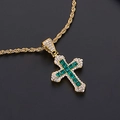 Vue macro d'un pendentif croix doré avec pierres vertes carrées et diamants blancs - Collier Croix Zirconia Vert Or