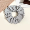 Detail shot of a grey oversized fabric scrunchie showing pleated texture on white background - Gray