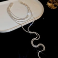 Makroansicht der mehrlagigen Strass-Halskette mit fließenden Quasten und brillantem Funkeln - Silberner Mehrschichtiger Strass-Quastenstil
