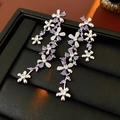 Macro shot of sparkling purple zircon flower tassel earrings with silver base on black box - Purple (925 Silver Pin)