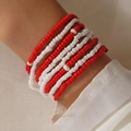 Bohemian body chain with red and white beads layered on the wrist in a beach style - Red And White Intersecting Style (0032)