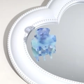 Macro view of blue marbled acetate hair claw clip reflecting on a heart-shaped mirror - Blue