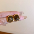 Brown agate stud earrings with golden rectangular frame held in hand for detail - No.2 Coffee Trapezoid Resin Stud Earrings (S925 Pin)