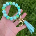 Detail of colorful silicone beaded keychain with light blue tassel and golden metal clasp - Mint Green Leopard Style / Blue