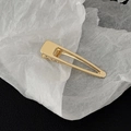 Close-up of golden minimalist metal duckbill hair clip with polished mirror finish - Gold Glossy Square Head Style