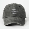 Dettaglio del ricamo DON'T FORGET TO SMILE su cappellino in cotone grigio scuro lavato - Nero