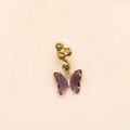 Detailed close-up of golden metal butterfly pendant with purple crystals and small diamonds - Purple Crystal Gold