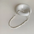 Close-up of a silver faceted bead necklace with high metallic luster and extension chain - Silver