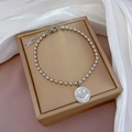 Nahaufnahme von silbernem Perlenarmband aus Titanstahl mit Smiley-Anhänger auf Samtschmuckbox - Silberfarbener Perlenstil Mit Weißem Muschel Smile Face (K334白银)