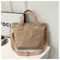 Detail of khaki oxford tote bag showing silver snap pocket and adjustable shoulder strap - Khaki