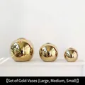 Three-piece gold spherical vase set with mirror finish in large, medium, and small sizes - A Set Of Golden Round Vases