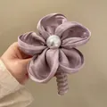 Dettaglio di elastico per capelli a fiore in raso viola con perla centrale e spirale - Stile Perla Raso Viola